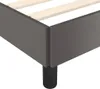 A close-up view of the corner of a grey bed frame with wooden slats visible inside. Náhled obrázku produktu