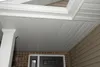 A view of a house exterior, focusing on the soffit and fascia of the roof, with a portion of the siding and a window visible. Produktbild-Vorschau