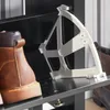 A close-up view of a shoe rack with a brown boot on the left and a white plastic shoe holder mechanism on the right. Náhľad obrázku produktu