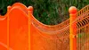 A close-up view of an orange metal fence with rounded tops on the posts. Anteprima dell’immagine prodotto