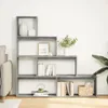 A modern, grey, multi-level bookshelf filled with decorative items and books, placed against a white wall. Náhled obrázku produktu