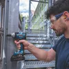 A man is using a Bosch cordless impact wrench on a metal structure next to a set of stairs. Voir les images du produit