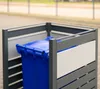 A blue trash bin inside a gray metal enclosure. Náhled obrázku produktu