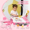 A child sits at a pink desk and chair set, drawing. Produktbild-Vorschau