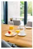 A breakfast setting on a wooden table with juice, coffee, and fruit. Produktbild-Vorschau