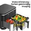 A close-up view of a dual-chamber air fryer with food in both baskets, highlighting a shake reminder feature. Produktbild-Vorschau