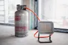 A portable gas heater connected to a gas cylinder, placed on a construction site windowsill. Anteprima dell’immagine prodotto