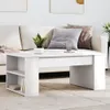 A white coffee table with shelves is placed in front of a sofa in a living room setting. Náhled obrázku produktu