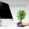 A hand holding a gray vertical mouse next to a computer monitor and a potted plant. Produktbild-Vorschau