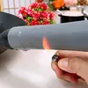 A hand holding a lighter to the handle of a pot or pan, with a flame igniting. Anteprima dell’immagine prodotto