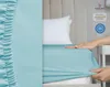 A hand is shown stretching a turquoise fitted sheet over a mattress, with a pillow in the background. Produktbild-Vorschau