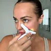 A woman is using a facial toning device on her face. Náhľad obrázku produktu