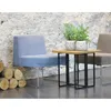 A modern living room setting with a blue chair, a small wooden table with plants, and a stack of logs. Náhľad obrázku produktu