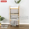 A bamboo laundry sorter with three fabric bins, displayed in a room setting with a plant and a basket. Anteprima dell’immagine prodotto