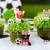 Close-up of decorated cupcakes with football player figurines and soccer balls. Anteprima dell’immagine prodotto