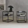 Two black metal bedside tables with shelves are shown in a room with a gray textured wall and a light gray floor. Anteprima dell’immagine prodotto