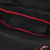 Close-up view of the interior of a black bag with a red zipper and a smaller zippered pocket. Produktbild-Vorschau