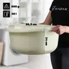 A person is holding a cream-colored plastic basin, with dimensions indicated by text overlays. Produktbild-Vorschau