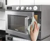 A hand is cleaning a Samsung microwave with a cloth. Náhľad obrázku produktu
