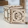 A wooden 3D puzzle safe with its door open, revealing intricate gears and a dial. A stack of coins is visible to the right. Produktbild-Vorschau
