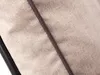 A close-up view of a beige fabric cushion with a dark brown trim. Náhled obrázku produktu