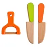 A set of wooden toy kitchen utensils, including a peeler and two knives, against a white background. Náhled obrázku produktu