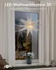 A white LED star decoration hangs in a window on a rainy day, with curtains drawn to the sides. Produktbild-Vorschau