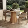 An outdoor patio setting with a round wooden table and two chairs, featuring a coffee set and a newspaper on the table. Produktbild-Vorschau