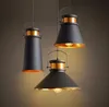 Three industrial-style pendant lights with black metal shades and gold interiors hang against a dark background. Náhled obrázku produktu