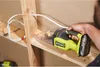 A person is using a handheld vacuum cleaner to clean sawdust from wooden beams and shelves. Podgląd zdjęcia produktu