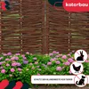 A woven willow fence bordering a flower bed with hydrangeas. Anteprima dell’immagine prodotto