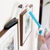 A person is using a vacuum cleaner attachment to clean the frame of a picture on a wall. Anteprima dell’immagine prodotto