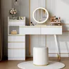 A white vanity desk with a round LED mirror and a matching stool, displayed in a well-lit room. Voir les images du produit