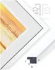 A close-up view of a white picture frame with a matted opening, revealing a portion of a colorful abstract artwork. A sample of the frame material with dimensions is shown in the lower right corner. Produktbild-Vorschau