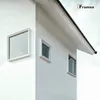 A close-up view of a modern white building corner with three windows and a dark roof against a cloudy sky. Náhľad obrázku produktu