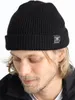A man wearing a black beanie with a skull and crossbones logo. Produktbild-Vorschau