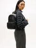 A woman wearing a sweater and pants is modeling a black backpack. Produktbild-Vorschau