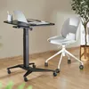 A mobile laptop desk and a chair are set up in a room with a plant. Náhled obrázku produktu