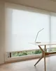 A roller blind is shown in a room with a desk and a lamp. Produktbild-Vorschau