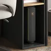 A computer tower with green LED lighting is placed inside a black cabinet next to a chair. Produktbild-Vorschau