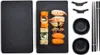 A sushi serving set with sushi, chopsticks, and dipping bowls arranged on black slate plates. Voir les images du produit