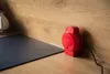 A red waffle maker is placed on a wooden countertop next to a dark gray stovetop. Produktbild-Vorschau