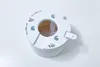 A white plastic mounting bracket for a camera is shown on a white surface. Produktbild-Vorschau