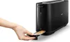 A person's hand is pulling out a crumb tray from a black toaster. Produktbild-Vorschau