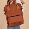 A person wearing a white shirt and blue jeans is carrying a brown rucksack. Voir les images du produit