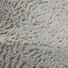 A close-up view of a gray shaggy rug. Voir les images du produit