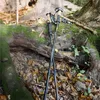 Two trekking poles leaning against a moss-covered log in a forest setting with fallen leaves. Podgląd zdjęcia produktu