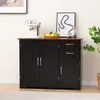 A black storage cabinet with a brown top, featuring two doors on the left and two drawers and a door on the right. A white coffee maker, a basket of fruit, and jars of coffee beans are on top. Podgląd zdjęcia produktu