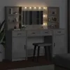 A vanity table with a mirror and lights, along with a stool, in a dimly lit room. Podgląd zdjęcia produktu