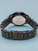 The back of a black watch with a metal band is shown against a light blue background. Anteprima dell’immagine prodotto